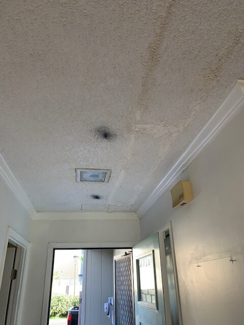 Damaged popcorn ceiling in hallway
