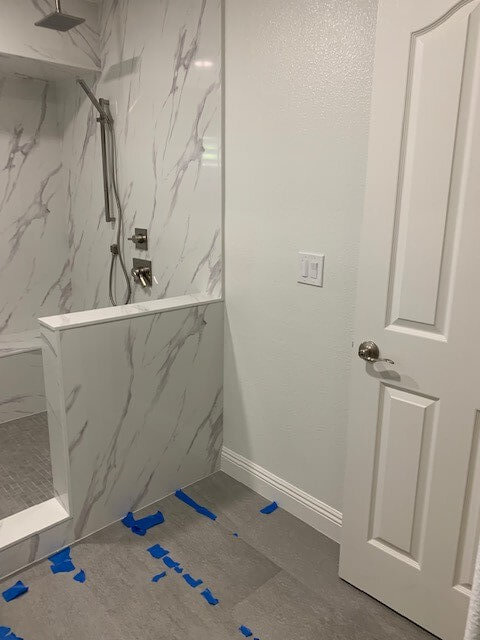 Stand up shower with marble walls and new vinyl flooring